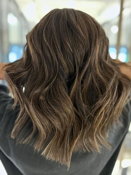 This warm-to-cool transformation shows how changing the tone of your highlights can create a whole new vibe. I finished the look with a textured haircut to add movement.
