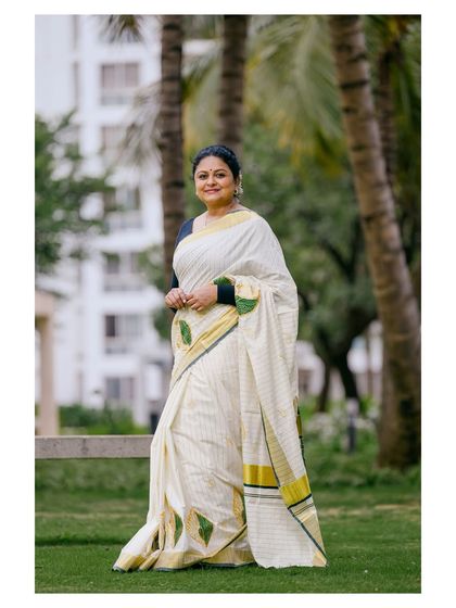 A full-length view of the Onam saree, capturing its classic elegance and the model's graceful movement.