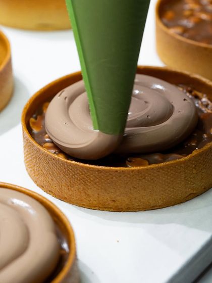 Piping a luscious chocolate crémeux into a tart shell, a technique taught in Chef Karim Bourgi's class.