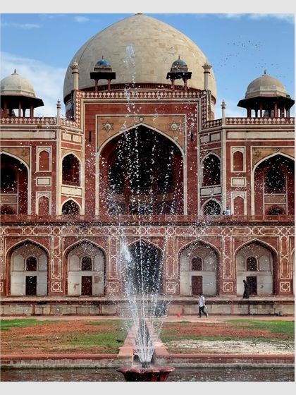 The magnificent facade of Humayun's Tomb in Delhi, with a fountain in the foreground. This moving postcard captures the grandeur of Mughal architecture.