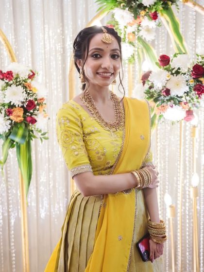 A full-length view of this graceful and simple look. The soft makeup perfectly complements the bright yellow of her lehenga.