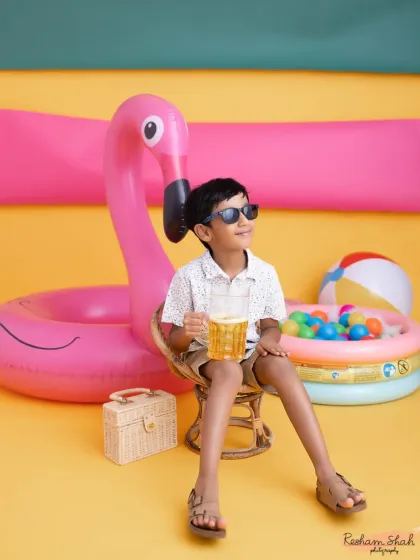 Just chilling with his flamingo floatie. The bright yellow background and fun props create a vibrant, summery feel right in the studio.