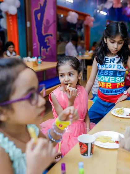 A young guest enjoying some french fries. Our menu includes a wide range of snacks perfect for a post-play treat.