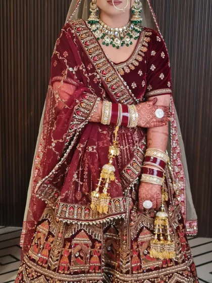 The full view of this bride's stunning maroon velvet lehenga. The makeup and outfit together create a truly royal look.
