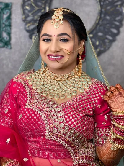 A happy bride in a pink lehenga, her smile is the main focus. The makeup is fresh and radiant.