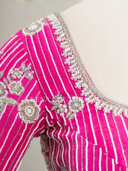 Pretty in pink, this raw silk blouse features intricate pearl and silver thread work in a striped pattern. I added floral motifs and delicate danglers on the sleeves for a touch of playful elegance.