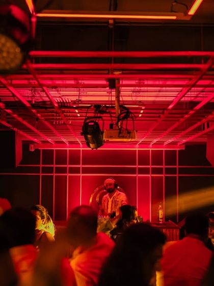 A wide shot of the console at Gawky Goose, with the crowd ready for a night of smashing Bollywood tunes.