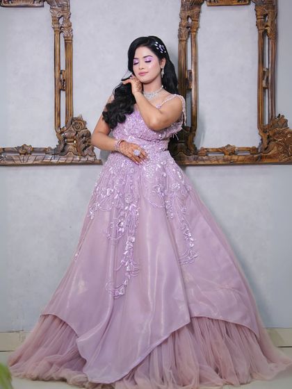 This pose highlights the full skirt and delicate details of the lilac gown.