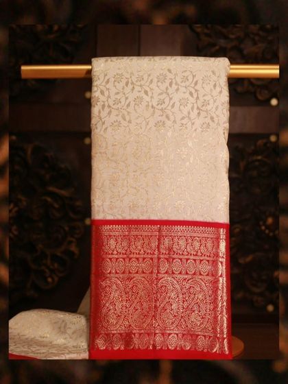 A classic white Kanjivaram with a rich red brocade border, a timeless and elegant combination.