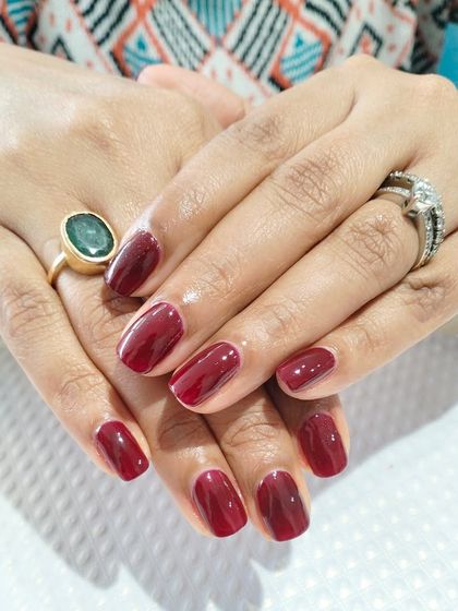 A beautiful, deep maroon color on shorter, squared-off nails, perfect for an elegant and understated look.