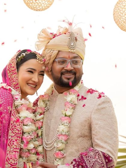 A happy moment of the couple being showered with petals after their beachside wedding ceremony.