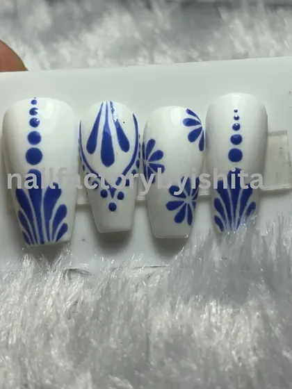 A beautiful blue and white porcelain-inspired design on a set of press-on nails.