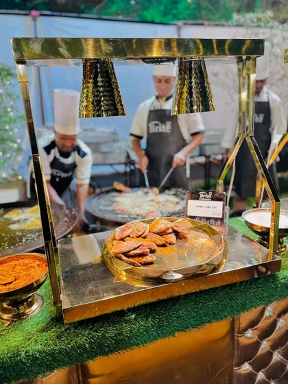 Another view of the golden, well-lit Surmai Tawa Fry counter, showcasing the delicious fish and the live cooking setup.