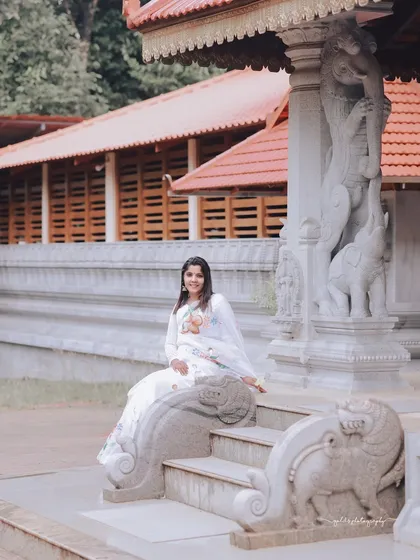 A beautiful portrait capturing the bride's smile against the intricate carvings of the temple architecture.