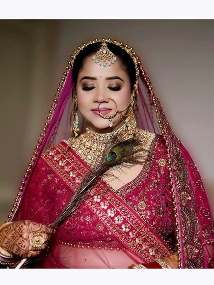 A serene bridal portrait featuring a peacock feather as a prop, adding a touch of traditional symbolism and elegance.
