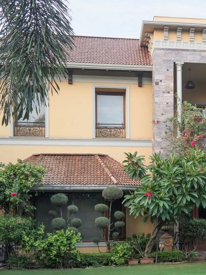 A duplicate image showcasing the luxurious house with its sandy yellow exterior and blend of modern and traditional architectural elements.