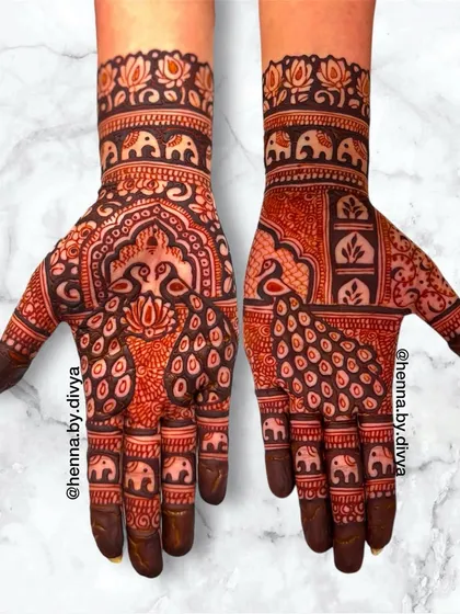 A full-hand design with a mix of peacock and elephant motifs. The intricate patterns and dense coverage make this a perfect choice for a bride or for a grand celebration.