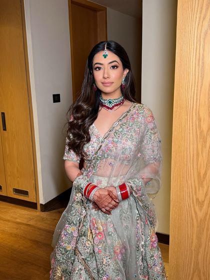 A full view of the bride's stunning pastel lehenga. The soft glam makeup ensures the focus remains on her natural beauty.