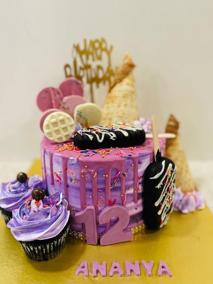 A fun and trendy ice cream themed drip cake for a 12th birthday. This purple cake is loaded with cakesicles, waffle cones, and matching cupcakes.
