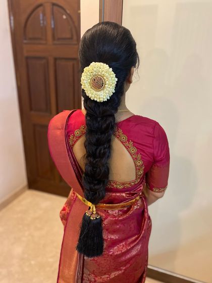A clean and elegant South Indian braid, perfect for any ceremony. The look is completed with a jasmine floral arrangement and a traditional kunjalam (tassel) at the end of the plait.