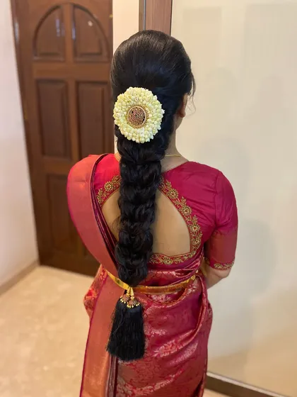 A classic, neat bridal braid for a traditional ceremony. The look is completed with a beautiful jasmine flower arrangement at the top and a traditional tassel, or 'kunjalam', at the end of the plait.