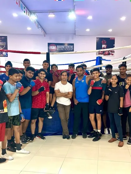 We are more than an academy; we are a team. A group photo of our students and coaches, celebrating the appointment of our founder to the International Boxing Association committee. Yahan hum ek family ki tarah train karte hain.