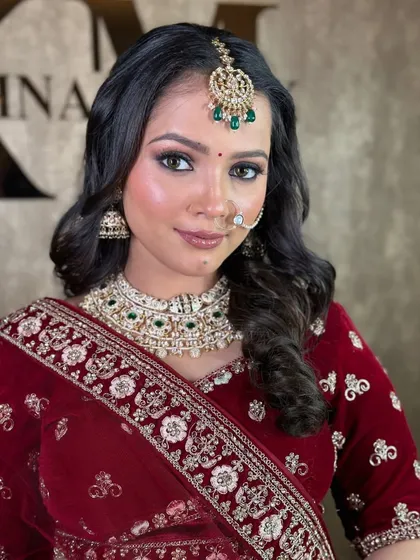 A close-up portrait showing the makeup and jewellery details with the maroon velvet lehenga. The nose ring and maang tikka complete the bridal look.