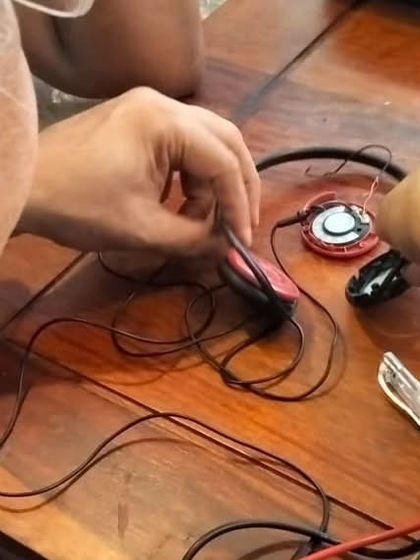 A detailed view of a headphone repair in progress. Students learn delicate tasks like soldering and wire repair, giving them the skills to fix their own personal electronics and save them from the landfill.