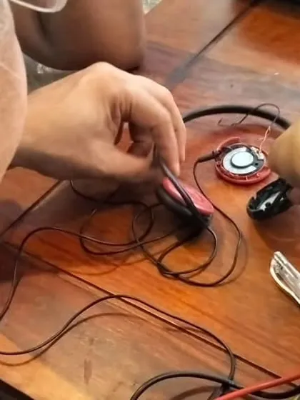 A detailed view of a headphone repair in progress. Students learn delicate tasks like soldering and wire repair, giving them the skills to fix their own personal electronics and save them from the landfill.