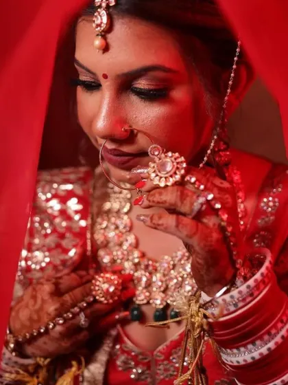 A bride in red is a timeless vision. This shot captures the elegance of a traditional bridal look, with a focus on the rich color palette, intricate jewelry, and the serene expression of a bride ready for her moment.