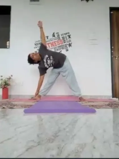 An instructor demonstrates Trikonasana (Triangle Pose) during a mid-morning online class. This classic standing pose stretches the entire side of the body and improves balance and stability.