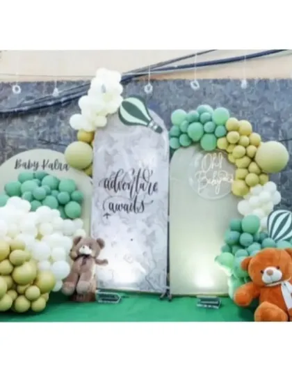The main backdrop for a baby shower, featuring 'Adventure Awaits' and 'Oh Baby' signs, surrounded by teddy bears and balloons.