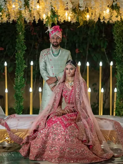 A regal and composed wedding portrait. The couple is posed on an elegant chaise lounge, creating a look of royal sophistication.