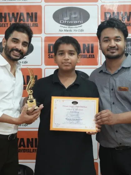 Two teachers congratulate a student on his win.