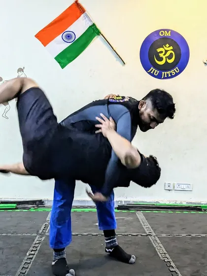 Grappling is the core of what we do. Here, I'm demonstrating a hip toss, a fundamental wrestling technique that is crucial for controlling an opponent in MMA and self-defense situations. Understanding how to transition from standing to the ground is a game changer.