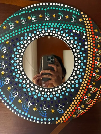 A finished spiral mandala mirror, with a fun selfie reflection of the proud artist who made it.