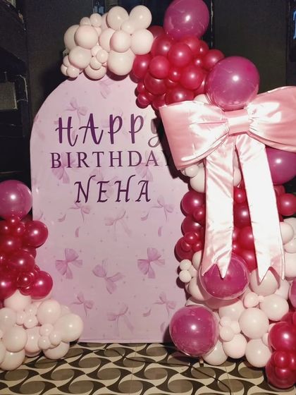 Wrapped in love and tied with a bow! This incredibly sweet birthday theme for Neha features a custom arched backdrop and a stunning, oversized pink satin bow as the centerpiece of the balloon garland.
