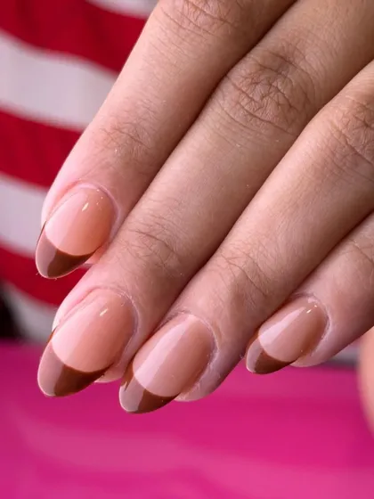 A warm and sophisticated French manicure. This look features a rich, caramel brown tip on a classic sheer base for a chic and understated style.
