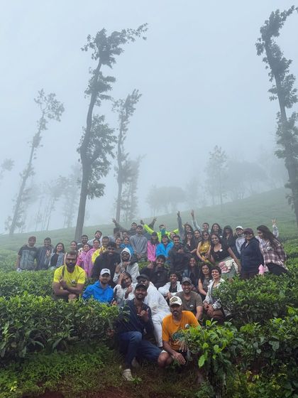 A large group photo amidst the misty tea estates on the Bandaje trek.