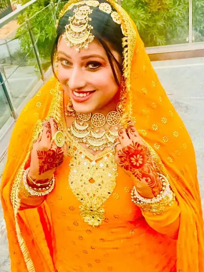 A happy client ready for her Haldi ceremony. I provided the vibrant orange suit, the heavy gold-plated jewellery, and the glowing makeup.