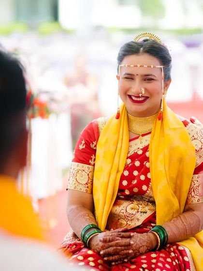 A candid shot of the bride's bright, happy smile during her wedding ceremony, capturing a moment of pure joy.