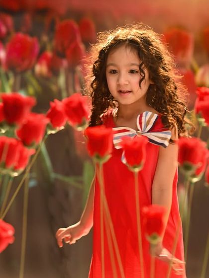 A field of red tulips, created with a combination of a projected background and physical props. This shot shows how to blend digital and real elements for a charming and innocent portrait.
