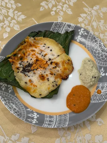 A beautifully plated Khada Masala Spot Idli, served on a banana leaf with two types of chutney. This image highlights the thoughtful presentation of our fusion dishes.