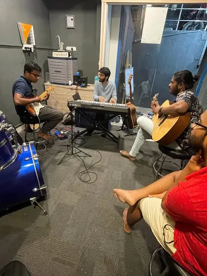 Our jam room is fully equipped for your entire band. This shot captures a typical rehearsal, with space for a full drum kit, keyboards, and multiple guitarists, ensuring you have everything you need to practice for your next gig or writing session.