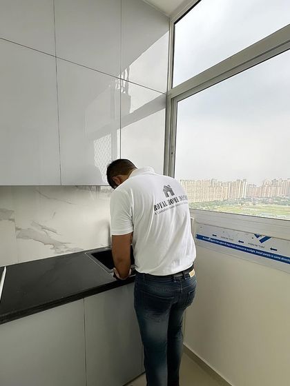 Final touches on a modular kitchen at Nirala Estate. Our team member is seen here ensuring the sink and countertop are perfectly installed.