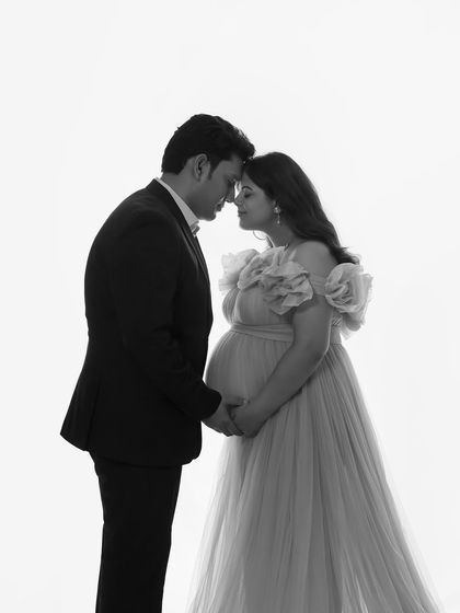 A timeless black and white couple's portrait. This intimate pose highlights the connection between the partners and the beautiful shape of the baby bump.