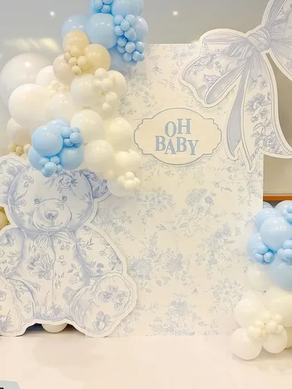 A truly luxurious baby welcome, this Dior-inspired theme uses a classic blue and white toile pattern. The elegant bow and custom 'Oh Baby' sign create a high-fashion, chic look.