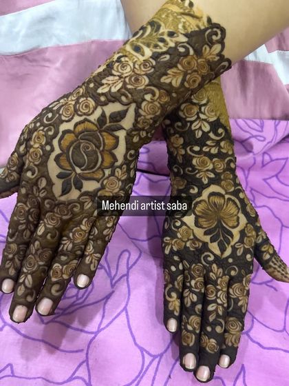 A beautiful semi-bridal design with large, bold flowers on the back of the hands. The dark henna makes the pattern very striking.