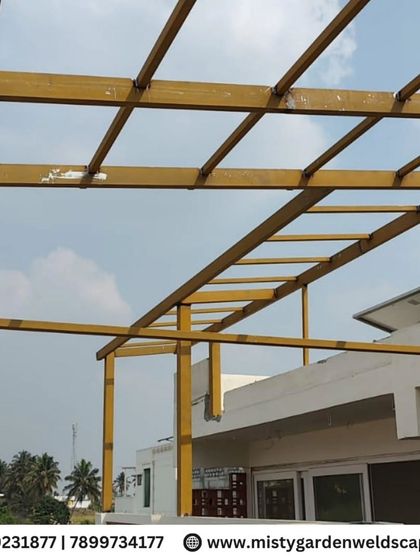 The yellow primer coat has been applied to this pergola frame, the first step in protecting the steel from rust and preparing it for the final color coat.