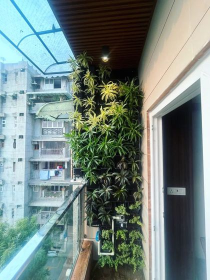 A natural vertical garden installed on a high-rise balcony. This living wall brings a breath of fresh air to the urban environment, complete with a self-sustaining irrigation system for easy maintenance.